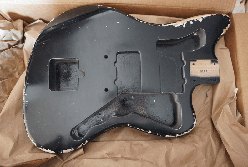 MJTの黒いJazzmasterボディーを梱包から開封している写真