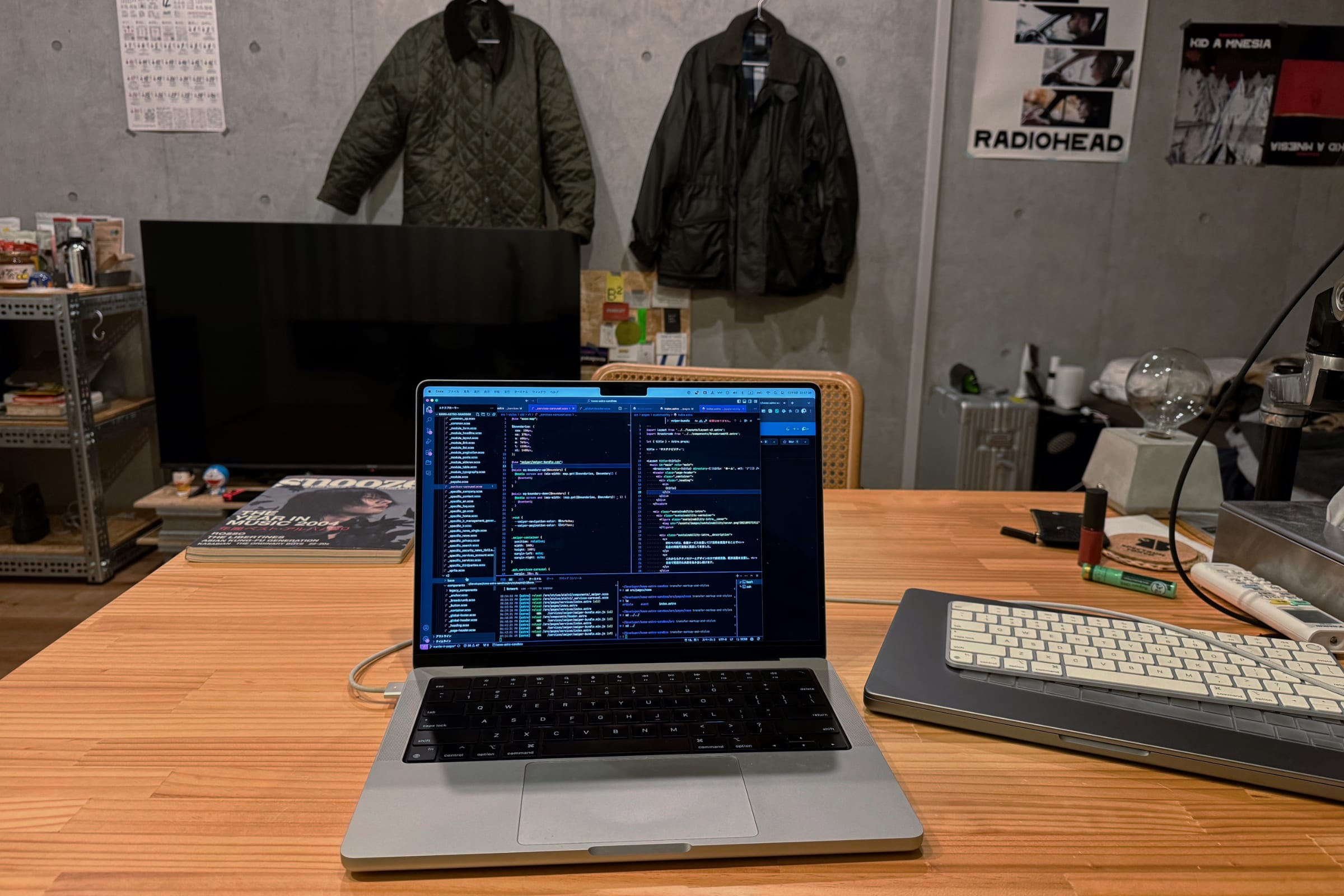 コードエディタが画面に映るノートPCを置いたテーブルと正対している部屋の写真