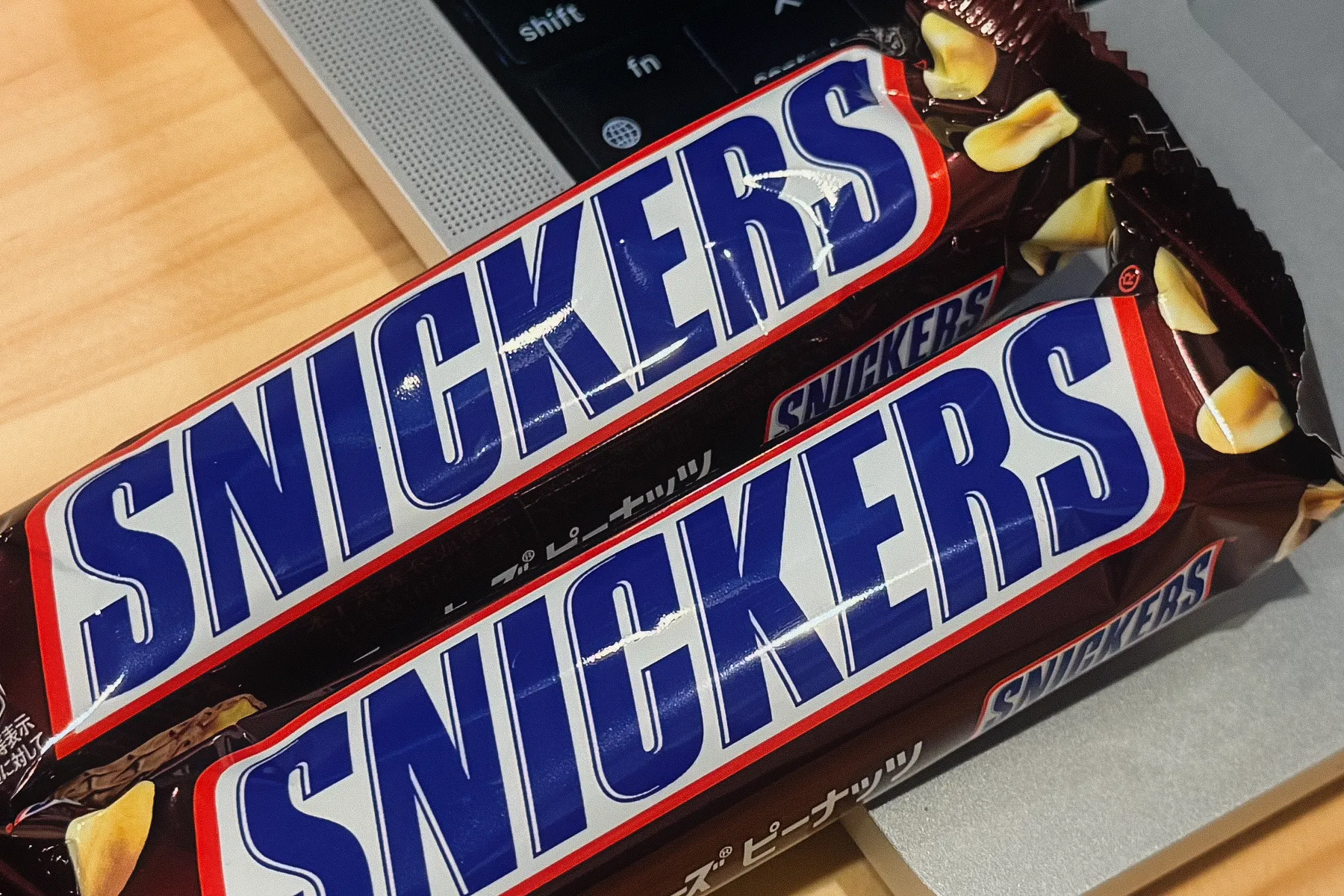MacBookのパームレストに2本のSnickersが載せられている写真